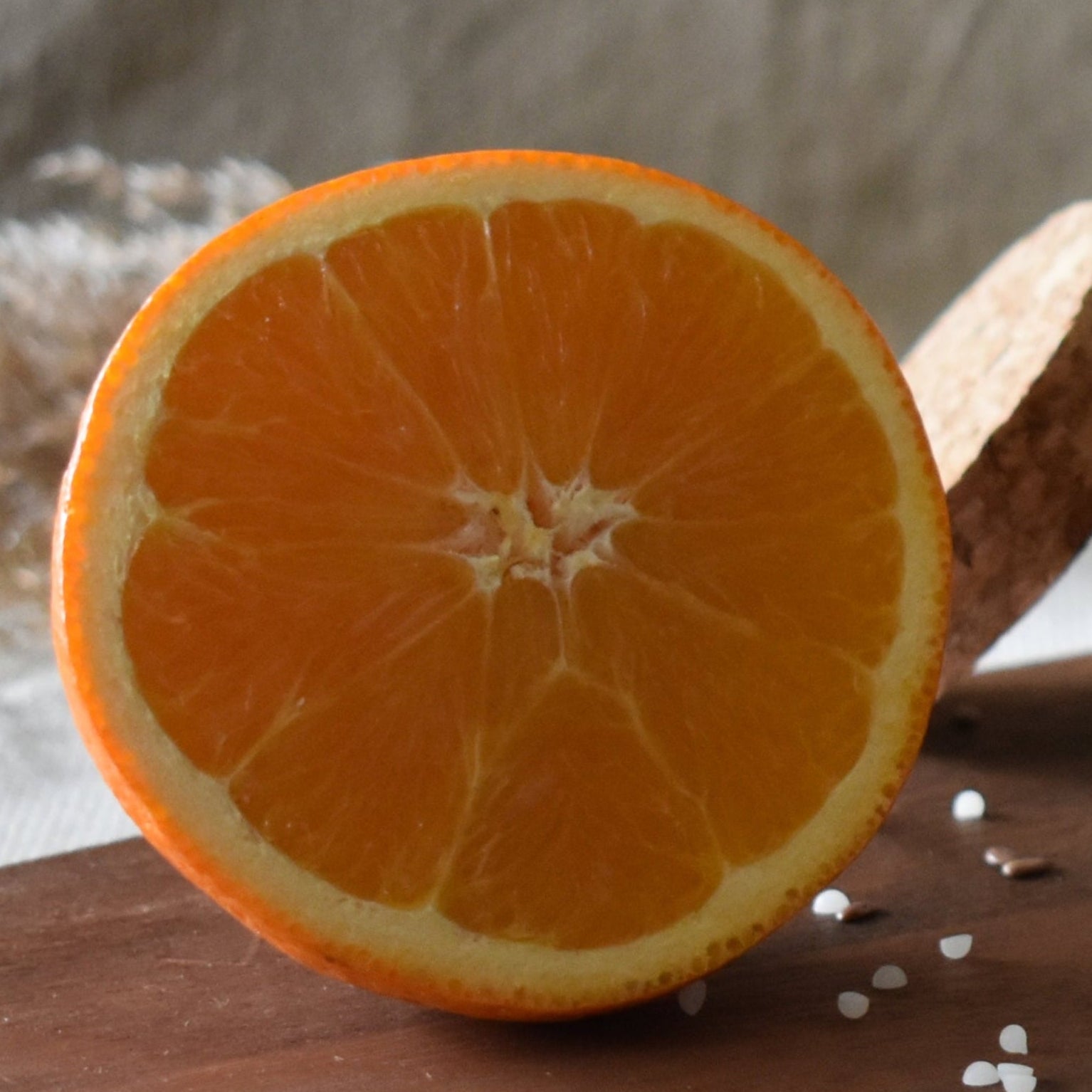 Half-cut orange on a wooden surface with a blurred background